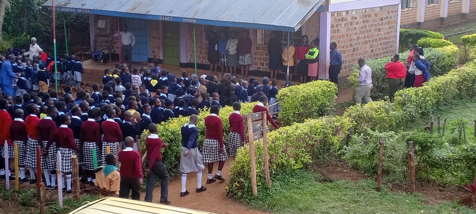 Teachers leading morning assembly outside the staff room