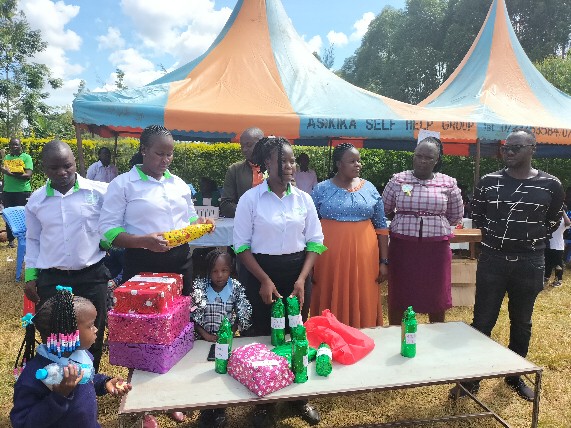 Staff and pupils at a celebration with gifts on a table