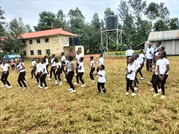 Learners practising a dance routine on the school field