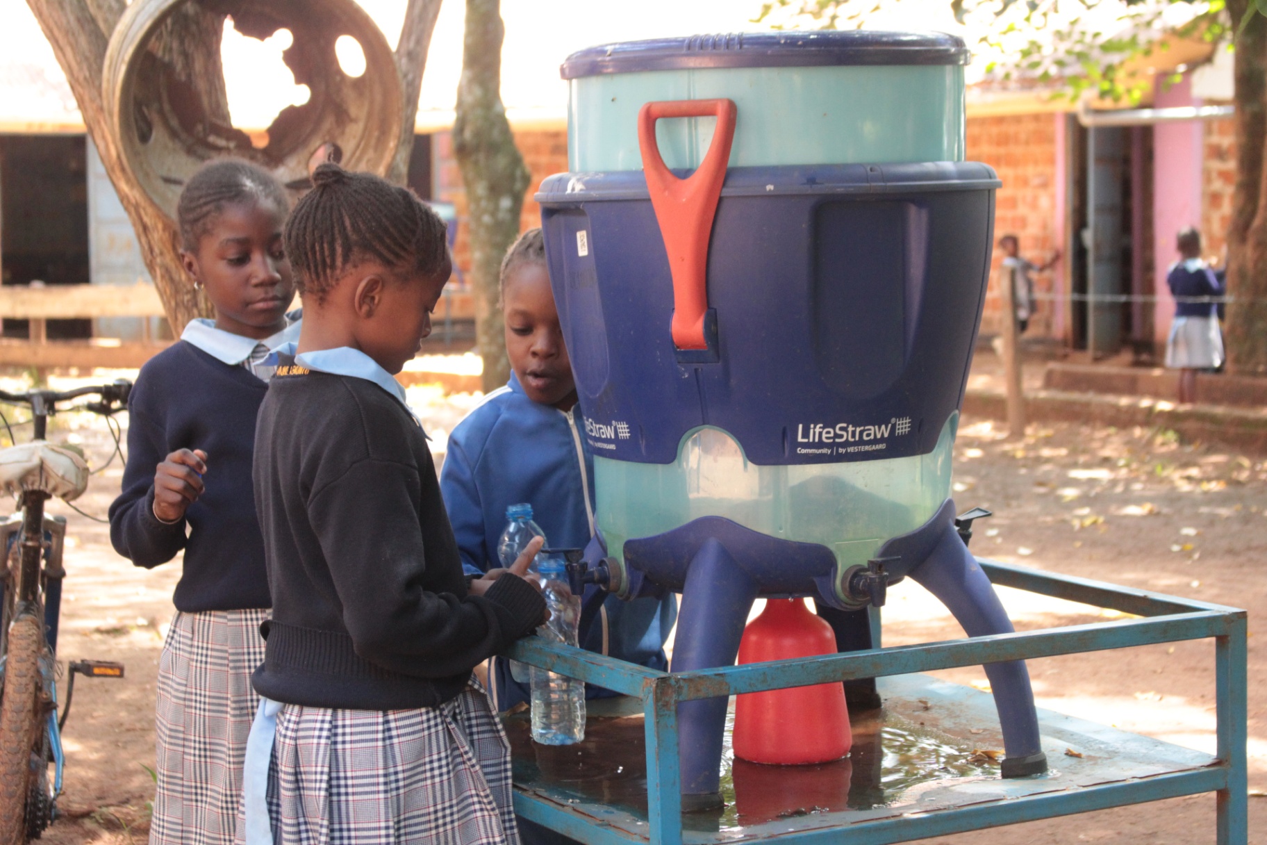 Pupils filling water bottles at a LifeStraw filter station